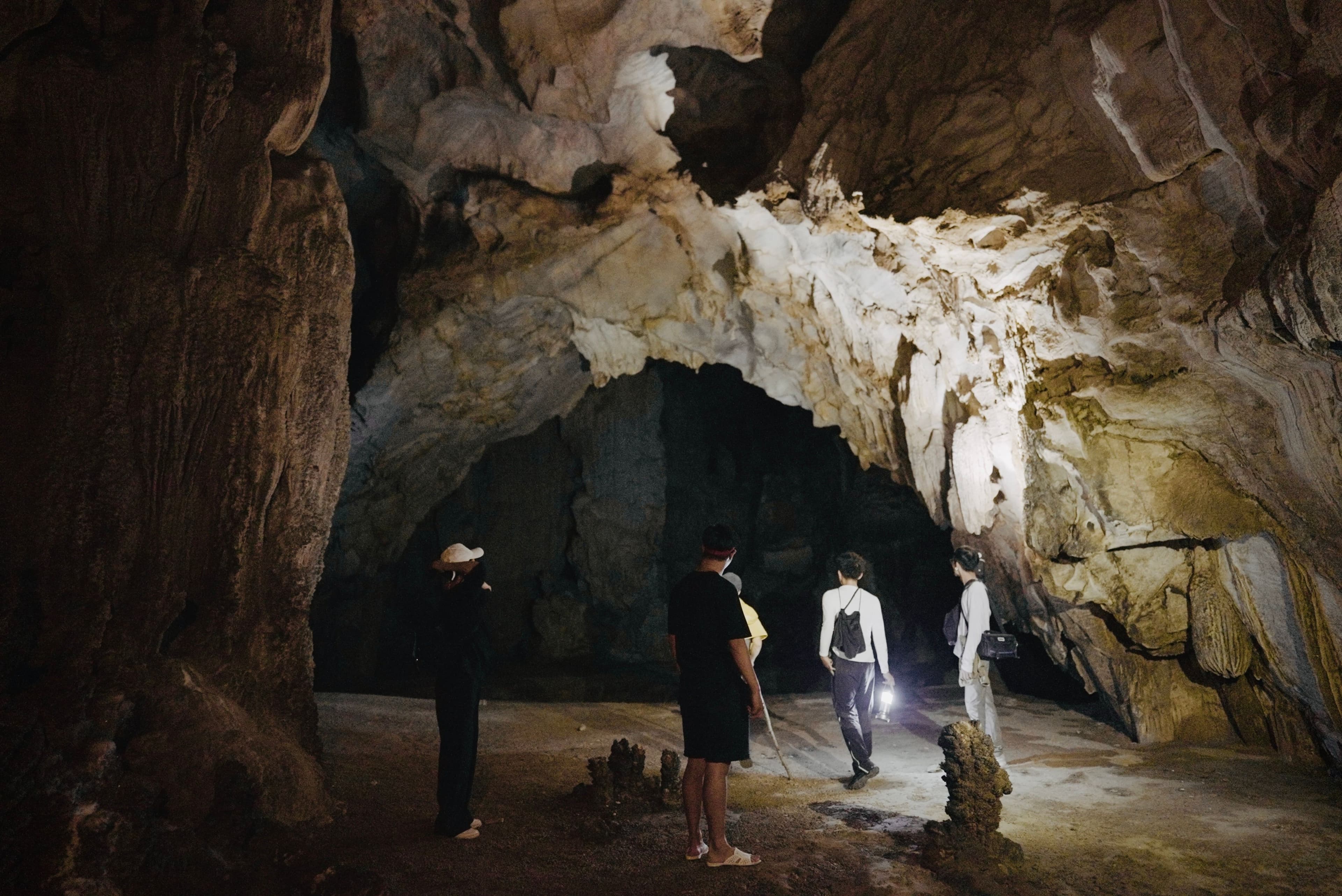 Tour group with headlamps exploring cave formations