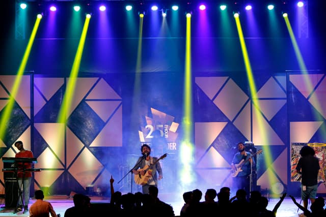 Music festival crowd in front of an illuminated outdoor stage